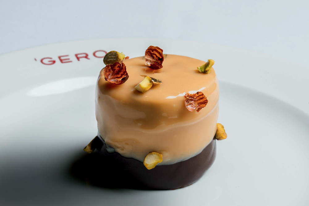 Dia dos Pais – Gero Sobremesa arredondada de cor creme com pistaches presos por fora em prato de louça branca.
