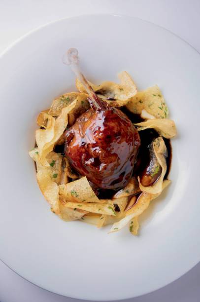 Pato confitado: com duo de batata chips em lâminas ao alho e purê Pato confitado: com duo de batata chips em lâminas ao alho e purê