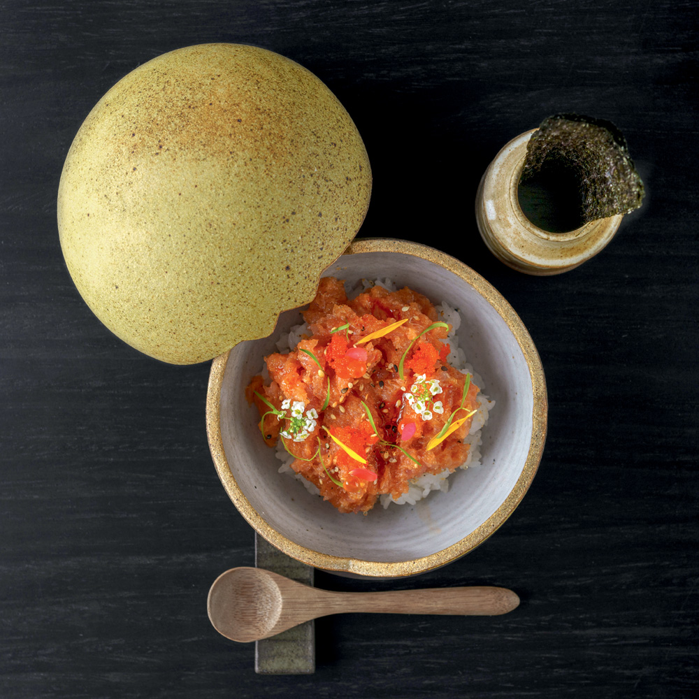 Foto a&eacute;rea de potinho de cer&acirc;mica com colher de madeira embaixo com tartare de atum.