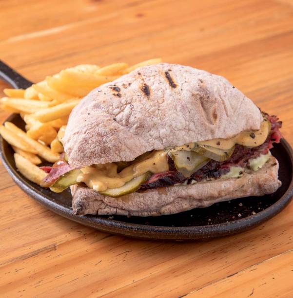 Pastrami: leva fatias do peito bovino, picles de pepino e molho de mostarda na ciabatta