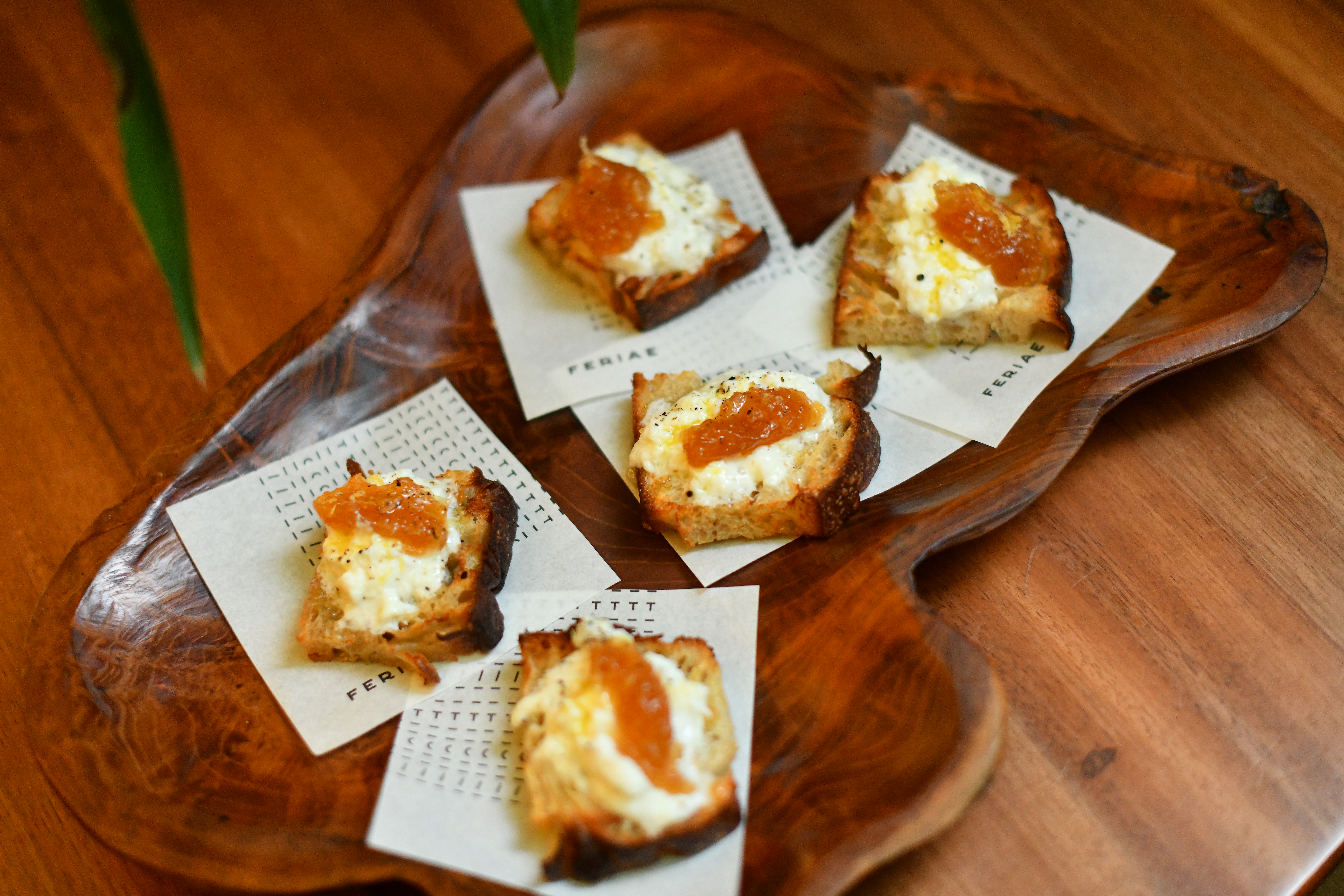 fatias de p&atilde;o cobertas por queijo cremoso com chutney por cima