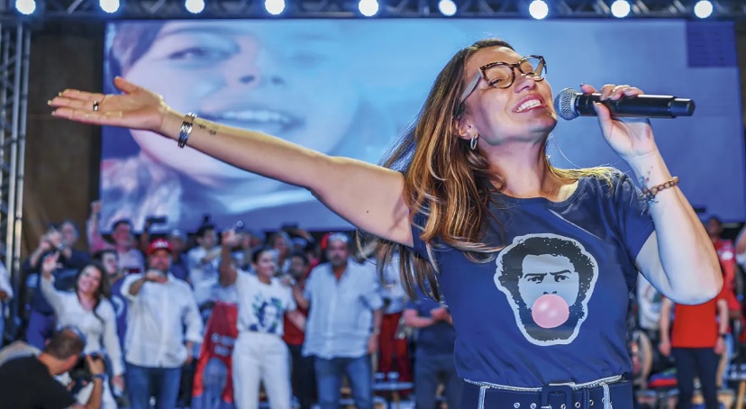 Imagem mostra janja sorrindo, com os braços abertos