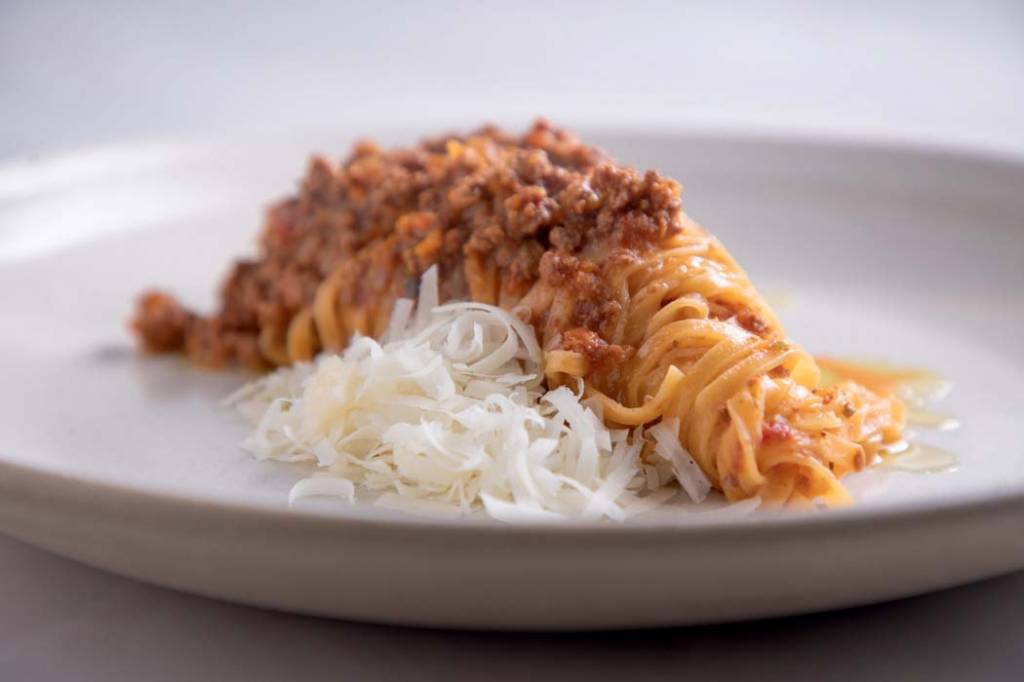 Simone Ristorante linguine-enrolado-em-prato-de-louça-branca-com-ragu-de-carne-e-queijo-ralado