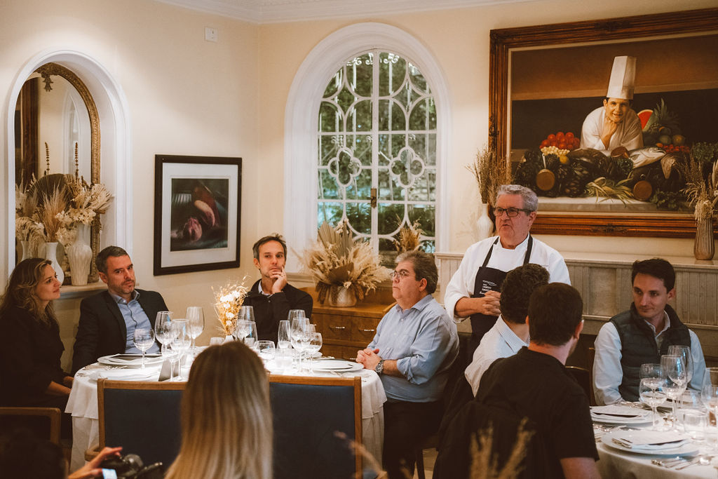 Sal&atilde;o com pessoas sentadas em mesas de jantar.