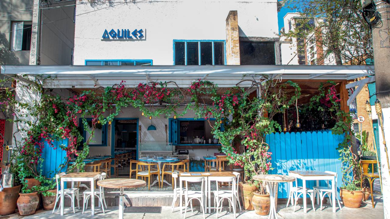Fachada do restaurante Aquiles com paredes brancas e detalhes azul.