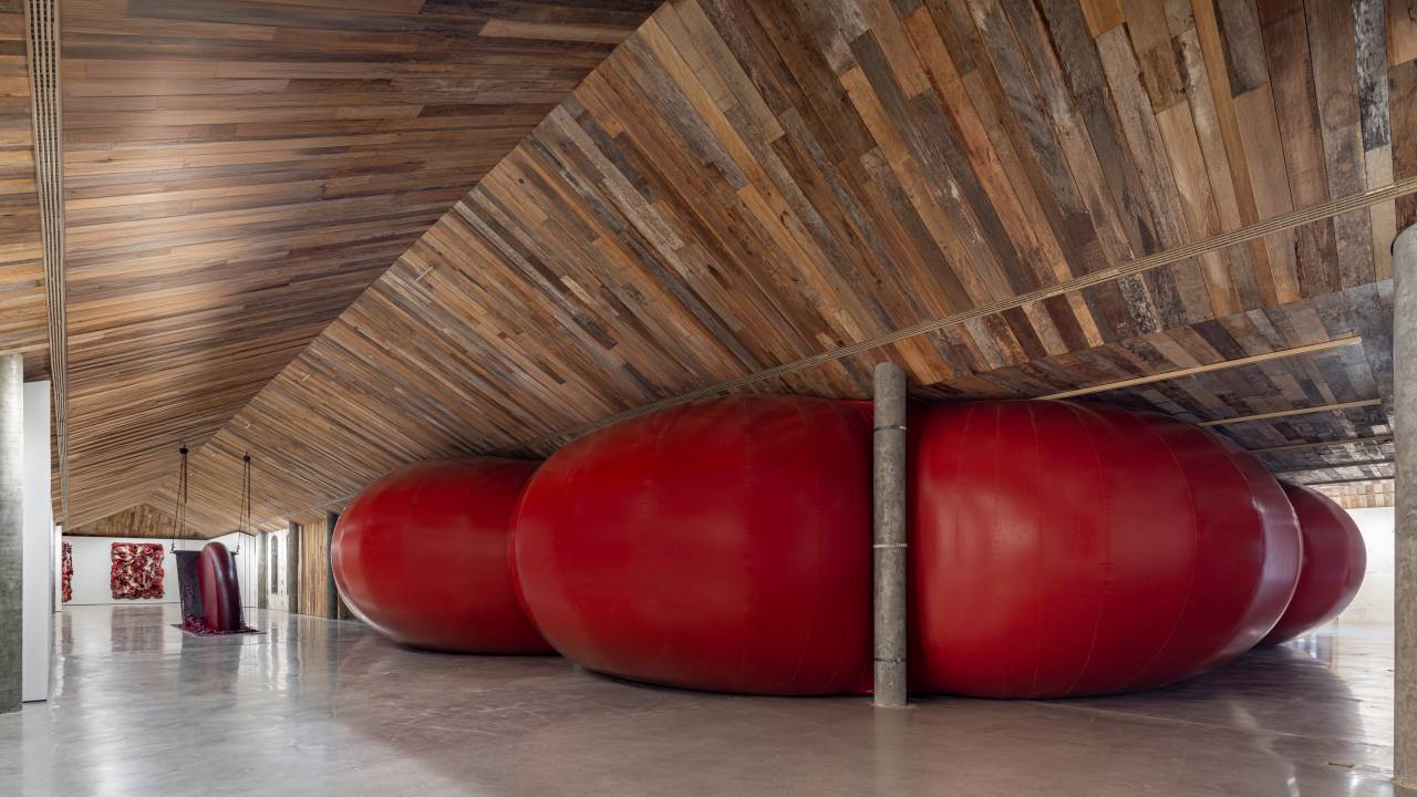 Inflável vermelho entre pilastras cinzas