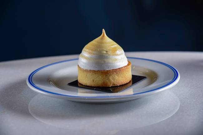 Ça-Vá Café Erick Jacquin – tortinha de limão 001 Torta redonda em cima de prato com fundo azul