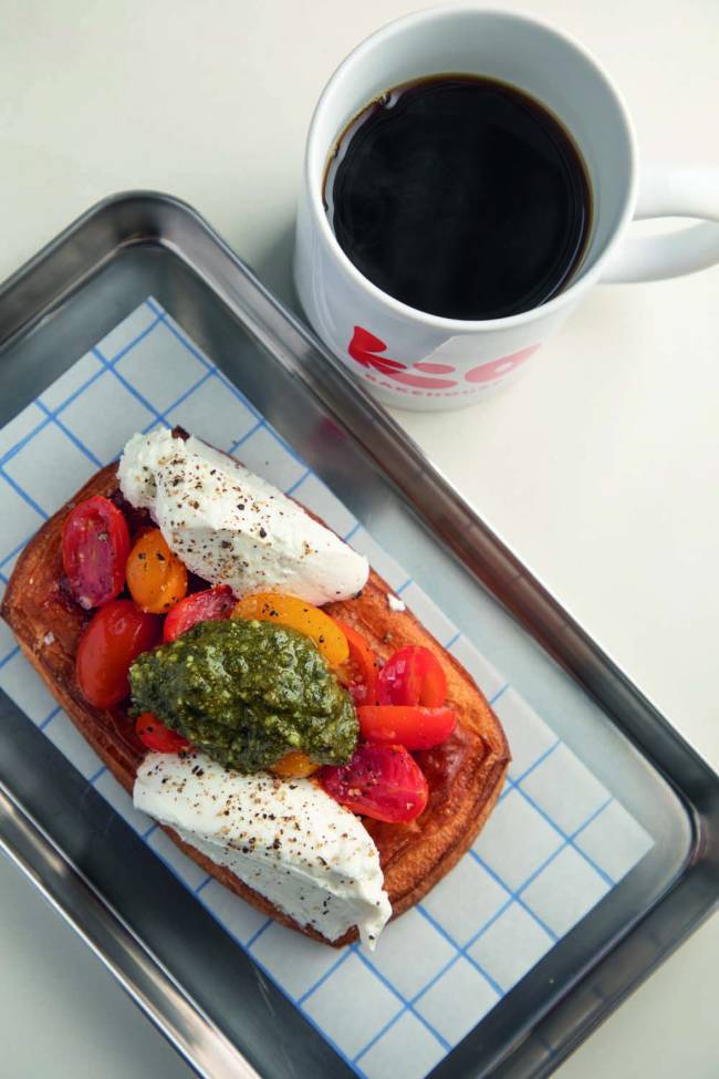 Kio Bakehouse Folhado caprese e caneca com café em cima de bandeja