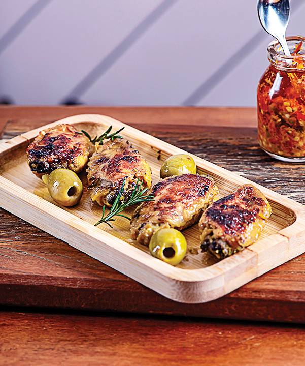 Prato de madeira com frango e azeitonas