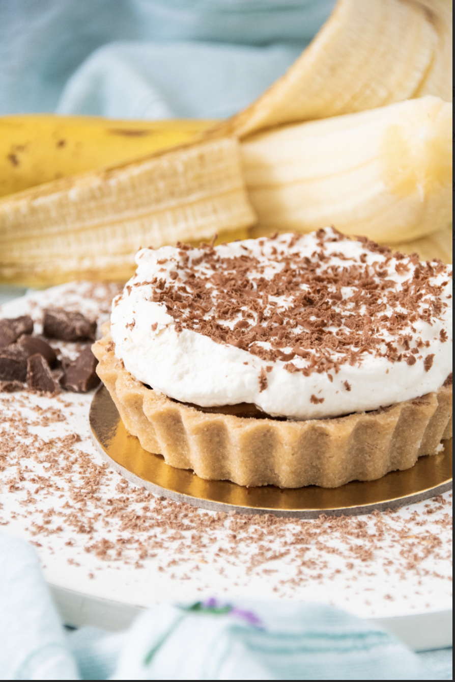 Torta em cima de recipiente dourado e banana atrás