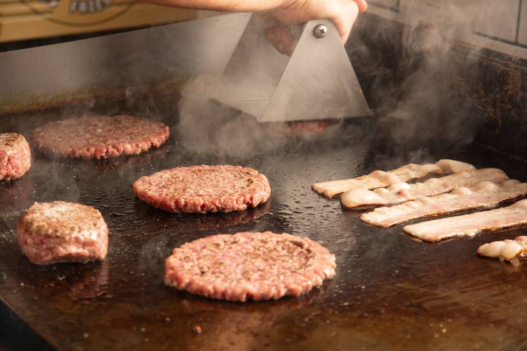 Burger iN Vários hambúrgueres sendo feitos na chapa