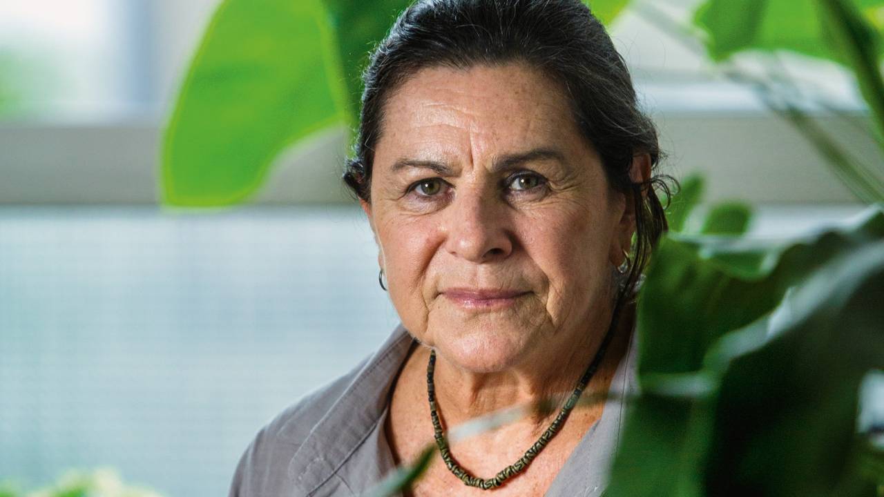 Mulher olhando para foto série e com plantas ao lado