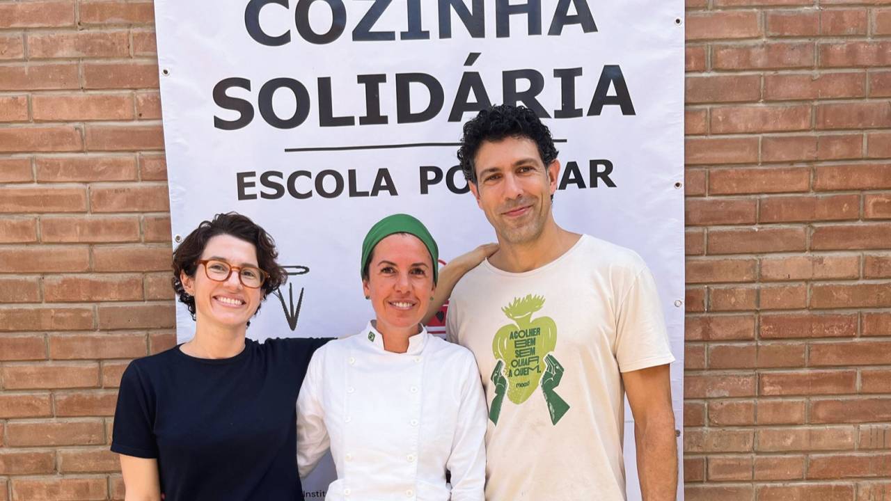 Três pessoas em pé e sorrindo
