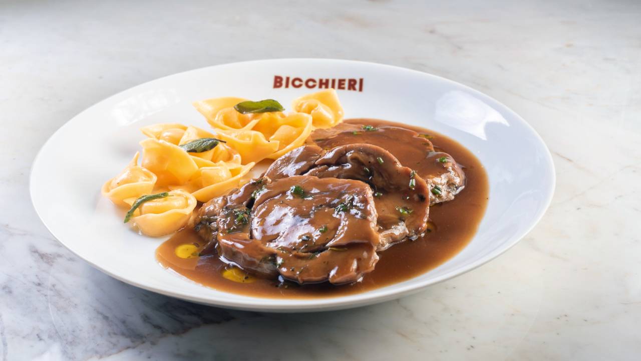 Macarrão e carne em cima de prato branco