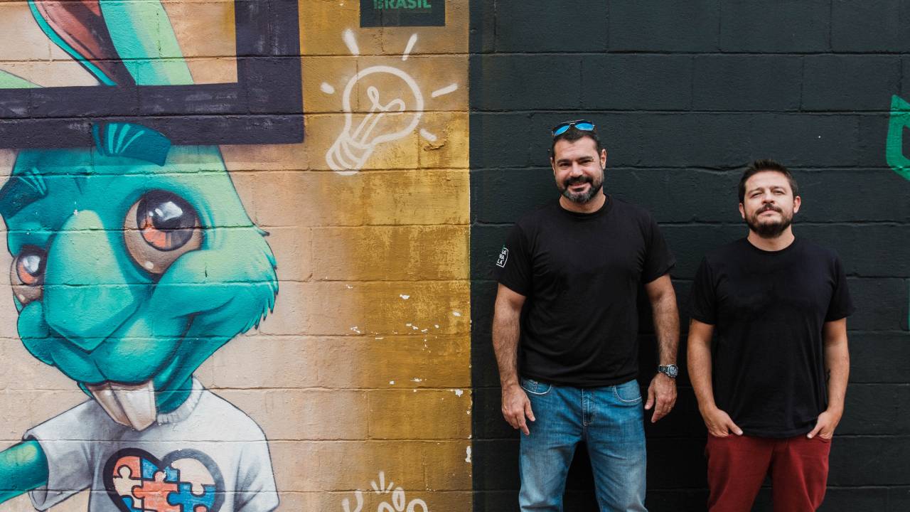 Dois homens de pé ao lado de grafite de coelho verde