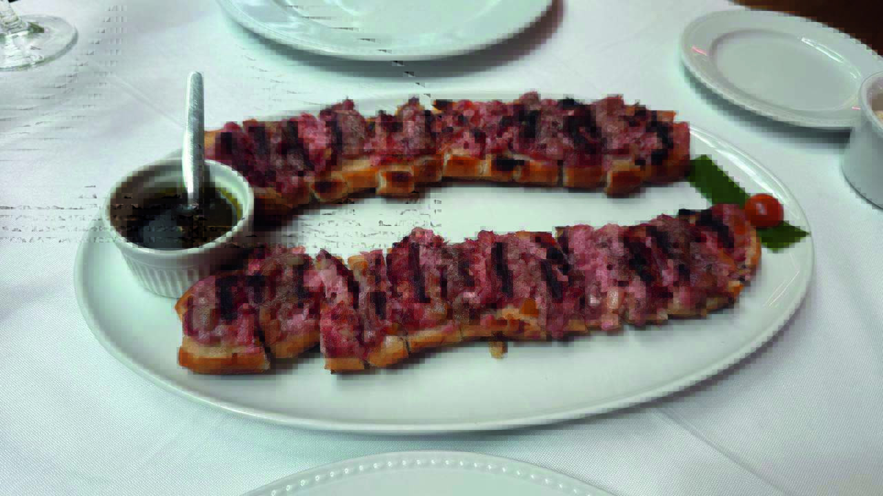 Lanche em cima de prato branco com molho ao lado
