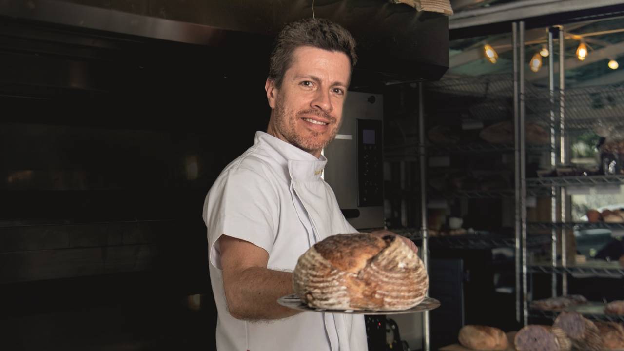 Homem segurando pão e sorrindo