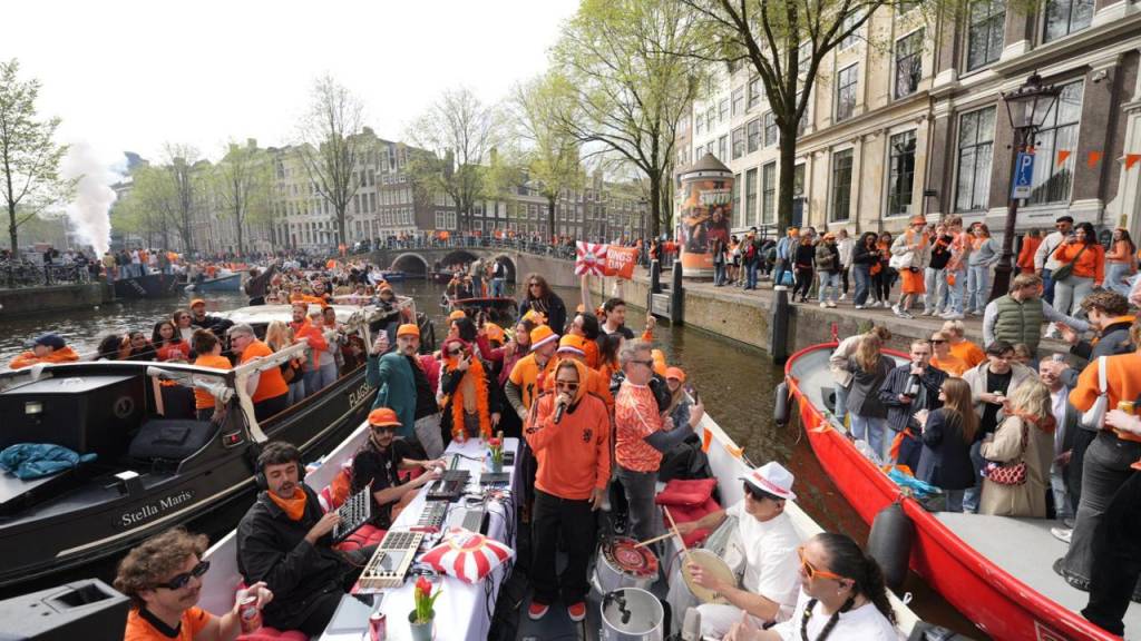 King’s Day em Amsterdã com Marcelo D2 Crédito Raphael Felisbino-Divulgação (2) Foto geral de barco com pessoas em tom laranja no canal de Amsterdã