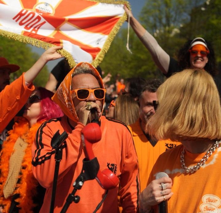 Foto de barco com pessoas em tom laranja no canal de Amsterdã