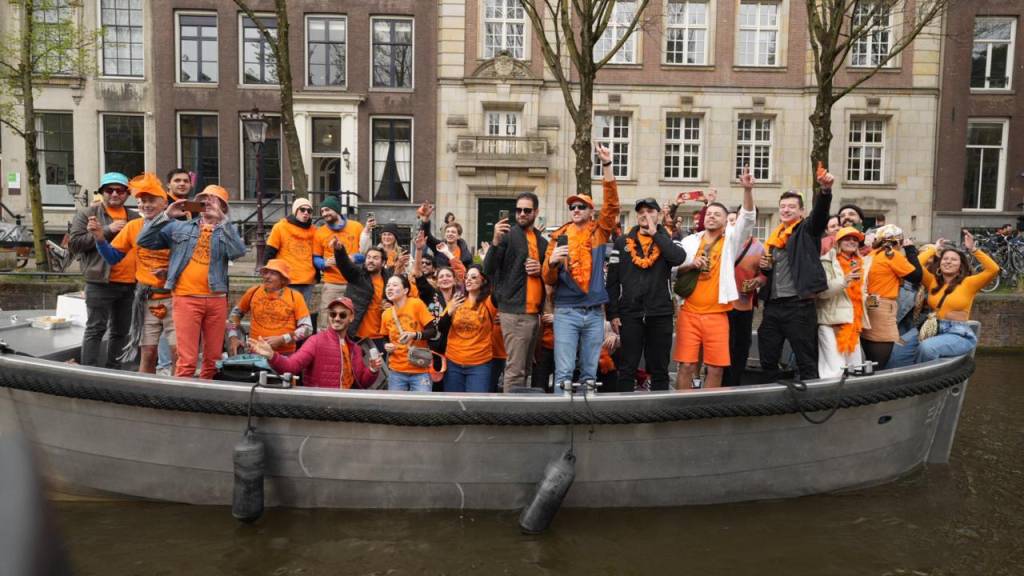 King’s Day em Amsterdã com Marcelo D2 Crédito Raphael Felisbino-Divulgação (4) Foto de barco com pessoas em tom laranja no canal de Amsterdã