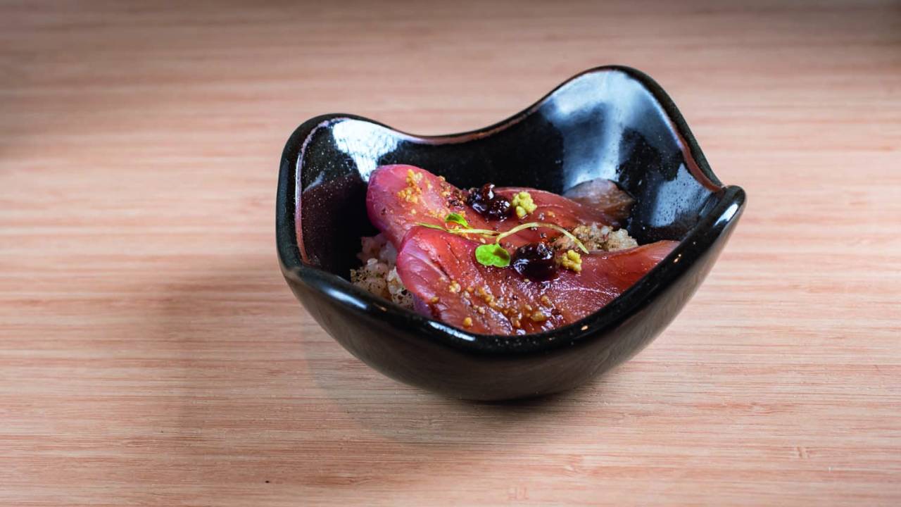 Pote escuro com peixe cru e temperos