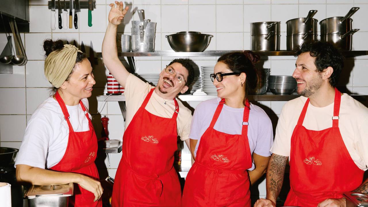 Quatro pessoas em uma cozinha sorrindo