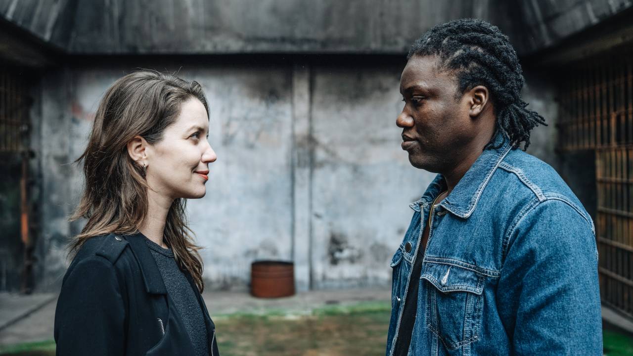 Nathalia Dill e Diderot Senat se encaram lado a lado em ambiente cinza