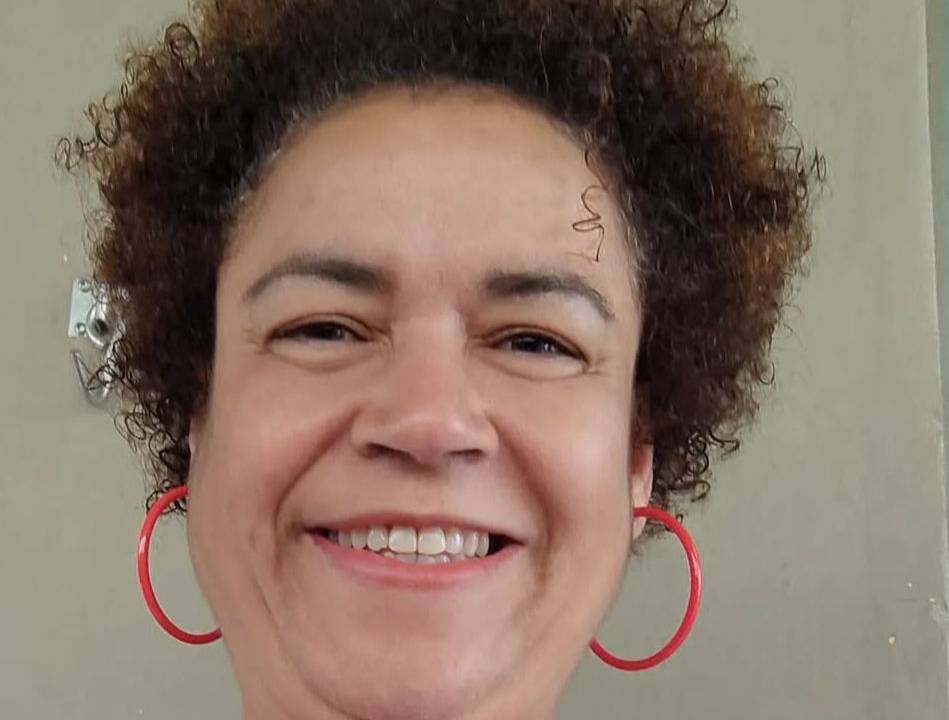 Mulher de cabelo crespos e brincos de argola vermelhos