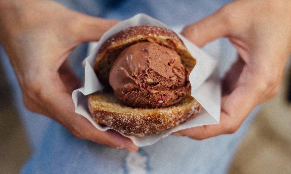 Pessoa segurando sonho com sorvete de chocolate