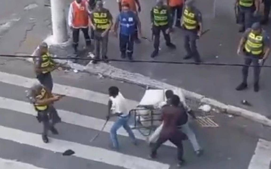Homens com arma em volta de outro homem