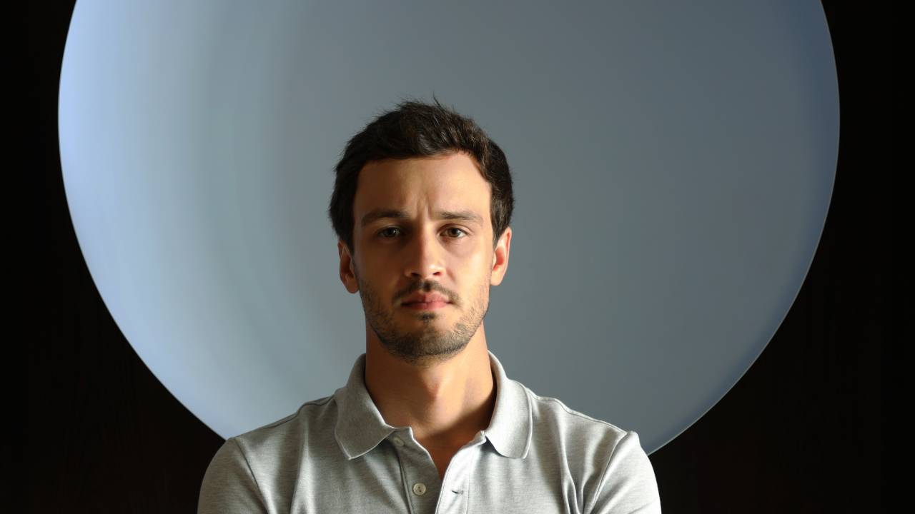Homem de polo em frente a grande luz branca