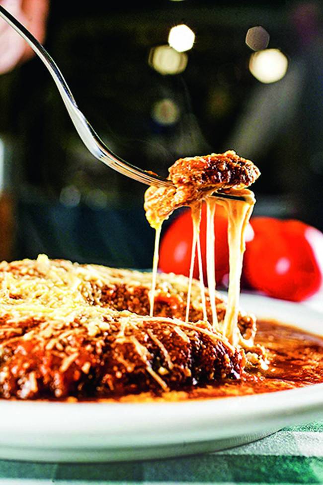 Prato com carne e garfo levantando pedaço