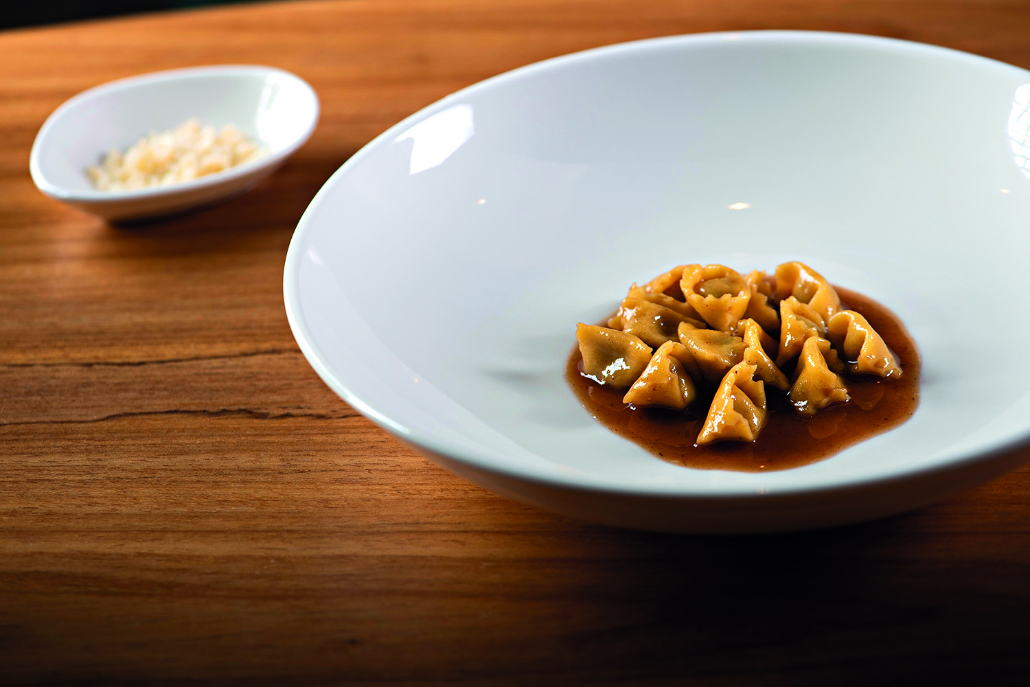 Prato com massa e molho em mesa de madeira